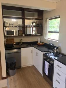 a kitchen with white cabinets and a stove top oven at Hermanus Heights Villa in Hermanus