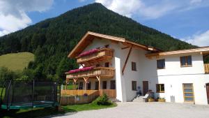 une maison avec une montagne en arrière-plan dans l'établissement Gästehaus Landhaus Tyrol, à Gries im Sellrain