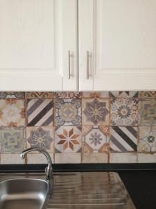 una cucina con lavandino e piastrelle sul muro di Apartment Conchiglie a Cala Gonone Altre 37 foto