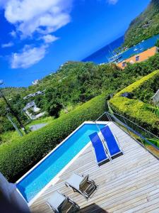 a swimming pool with lounge chairs and the ocean at Casa Vista in Marigot Bay