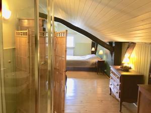 una camera con un letto in una stanza con pavimento in legno di Gîte la Semois à Mouzaive Vresse sur Semois a Vresse-sur-Semois