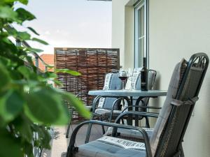 a patio with tables and chairs on a balcony at Obst- und Ferienhof Gomeringer in Immenstaad am Bodensee