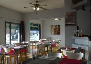 a restaurant with tables and chairs and a ceiling fan at Europa Hotel in Roussillon en Isere