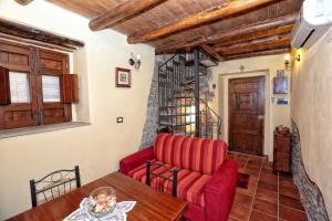 a living room with a red couch and a table at Al Castello in Brolo