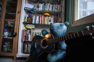 a teddy bear holding a guitar in a room at May Rooms Taipei Nangang Station in Taipei
