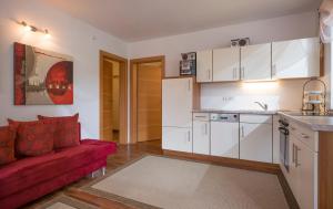 sala de estar con sofá rojo y cocina en Appartement Hoschek en Scheffau am Wilden Kaiser