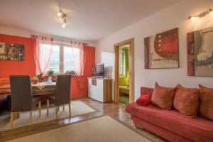 凱撒山麓舍福的住宿－Appartement Hoschek，客厅配有红色的沙发和桌子