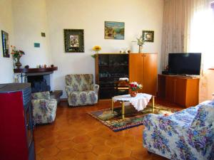 a living room with two chairs and a tv at Appartamento Panoramico in Montepulciano