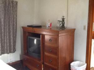 un tocador de madera con TV encima en Rosenberg Motel, en Galveston