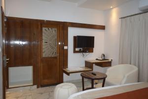a living room with a couch and a table and a television at Hotel Lok Sagar Mysore in Mysore