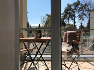 einen Tisch und einen Stuhl auf einem Balkon mit einem Fenster in der Unterkunft Ferienwohnung 1 18 Inselstrand in Ahlbeck