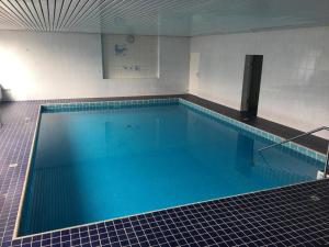a large swimming pool with blue water in a building at Wellness- & Golf-Appartement 2.2 Hebelhof in Bad Bellingen