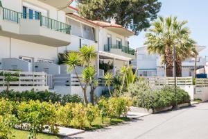 a building with palm trees in front of it at Minthi Boutique Apartments in Hanioti