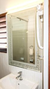 a bathroom with a sink and a mirror at Vivid Colombo in Colombo