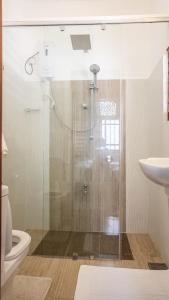 a bathroom with a shower and a toilet and a sink at Vivid Colombo in Colombo