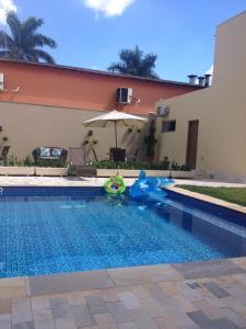 una piscina con un juguete frente a una casa en Solarium Park Hotel, en Adamantina