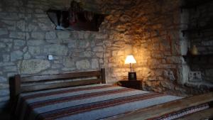 a bedroom with a bed in a stone wall at Filia House - Kalavryta in Klitoria