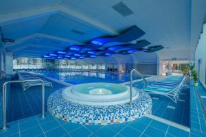a swimming pool with a hot tub in a building at Apartments Lovec in Cerkno