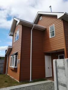 una casa marrón con una puerta blanca en Casa Amoblada Puerto Montt, en Puerto Montt