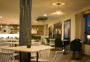 a restaurant with tables and chairs and a kitchen at Bellavista Bolonia in Bolonia