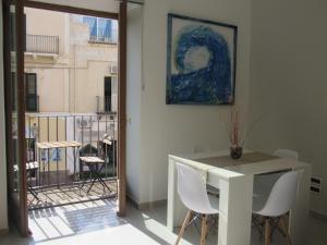 Habitación con mesa, sillas y una pintura en Polpo e Polpessa Casa Vacanze, en Lipari