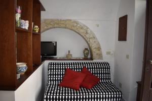 Habitación con sofá blanco y negro con almohadas rojas en Latte&Miele, en Ragusa