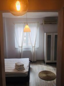 Schlafzimmer mit einem Bett und einem Fenster mit weißen Vorhängen in der Unterkunft Central Old city 2 in Bukarest