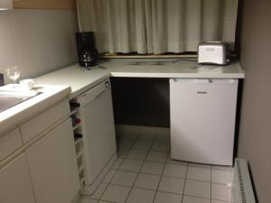 a small kitchen with a sink and a small refrigerator at Spacieux Appartement au coin de la plage in Middelkerke