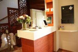 a reception counter with a vase of flowers on it at Gästehaus Gertrude in Velden am Wörthersee