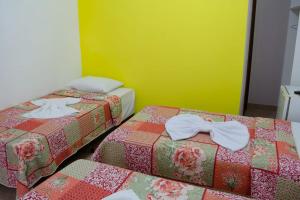 a room with two beds with bows on them at POUSADA DA ILHA in Una