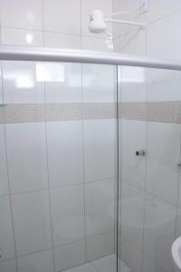 a bathroom with a glass shower and a sink at POUSADA DA ILHA in Una