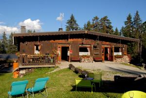 a building with chairs in front of it at Hôtel Chalet Le Caribou in Les Saisies