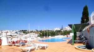 a pool with people laying on chairs next to a harbor at Varandas do Mar by Sunny Deluxe in Albufeira