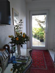 un soggiorno con porta e vaso con fiori di Swiss Borzoi House a Bellerive