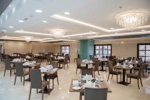 una sala da pranzo con tavoli, sedie e lampadari a braccio di Le Bosphorus Hotel - Waqf Safi a Medina
