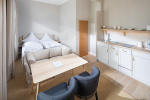 Habitación con cama, mesa y sillas. en Logierhaus Rosa-Lena, en Norderney