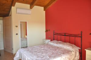 1 dormitorio con paredes rojas y 1 cama en Agriturismo Le Vigne, en Fermo