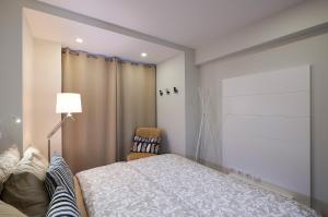 sypialnia z łóżkiem, lampką i krzesłem w obiekcie Braganza apartment w Funchal