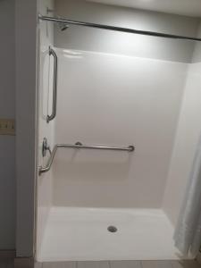 y baño con ducha y pared blanca. en Microtel Inn & Suites by Wyndham Augusta/Riverwatch, en Augusta