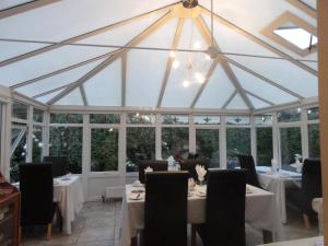 a conservatory with tables and chairs and a chandelier at Orley House B&B in Drogheda