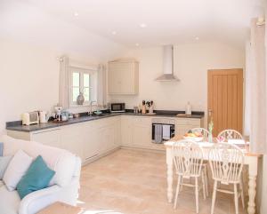een keuken en een woonkamer met een tafel en stoelen bij Hill Stables in Woodbridge