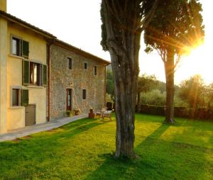 uma casa de pedra com uma árvore no quintal em Poggio Desto Bed & Breakfast em Quarrata