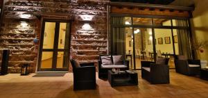 a lobby with chairs and tables and a brick wall at Art & Jazz Hotel in Catania