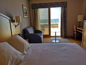 een hotelkamer met een bed en uitzicht op de oceaan bij Hotel Samar in A Lanzada