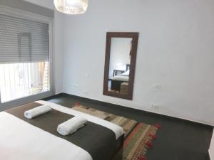 a bedroom with a mirror and a bed with towels at Total Valencia Mercado Central in Valencia