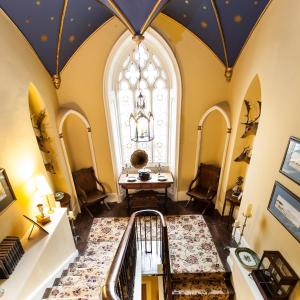 un corridoio mansardato con una grande finestra e una scala a chiocciola di Augill Castle a Kirkby Stephen