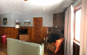 ein Wohnzimmer mit einem Stuhl und einem Kamin in der Unterkunft Stone Mountain Lodge in Lyons