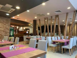 a restaurant with wooden tables and white chairs at Aspen golf studio apartment D208 in Razlog