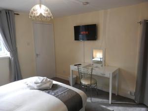 een slaapkamer met een bed, een bureau en een televisie bij Telford Claremont Mews Wellington in Telford