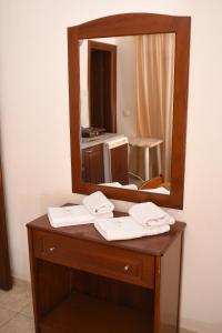 a bathroom vanity with a mirror and towels on it at Hotel Manos in Paralia Katerinis +29 photos